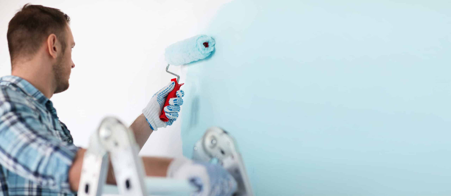 Close up of male in gloves holding painting roller