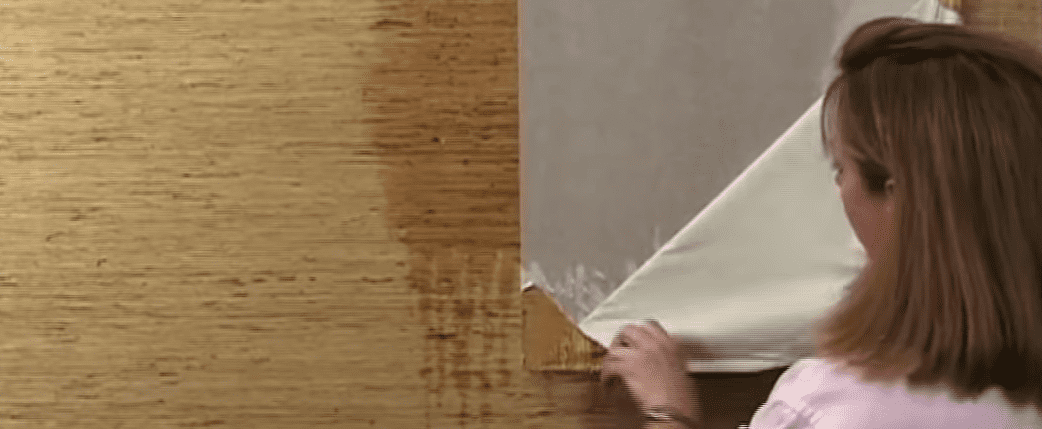 Woman Removing Grasscloth Wallpaper from the Wall