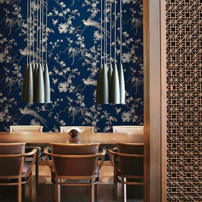 Room shot of navy blue chinoiserie wallpaper in a dining room.