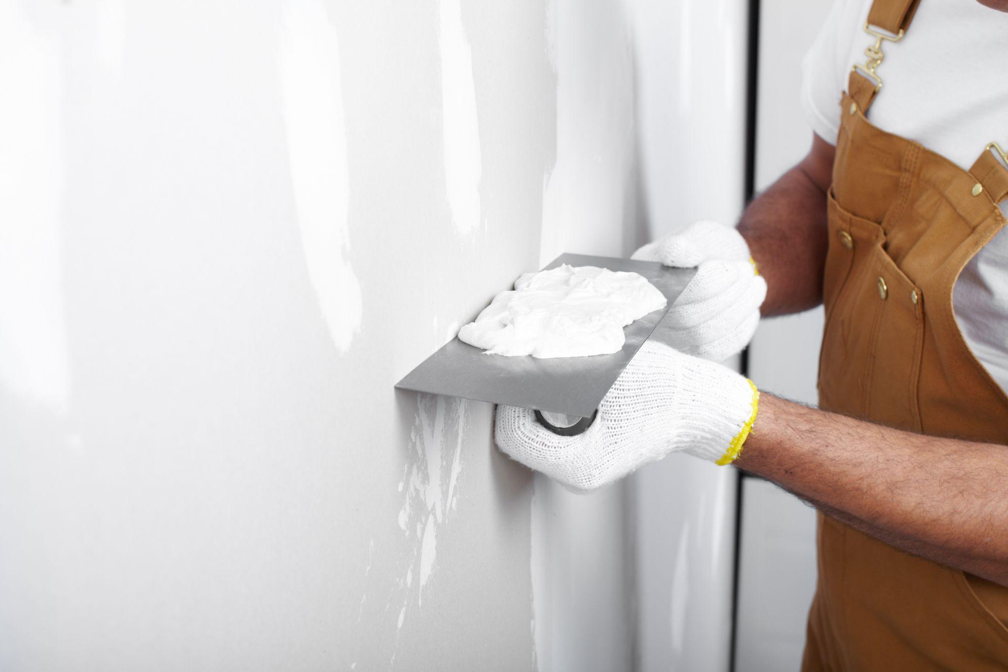 Worker applying plasterer on wall